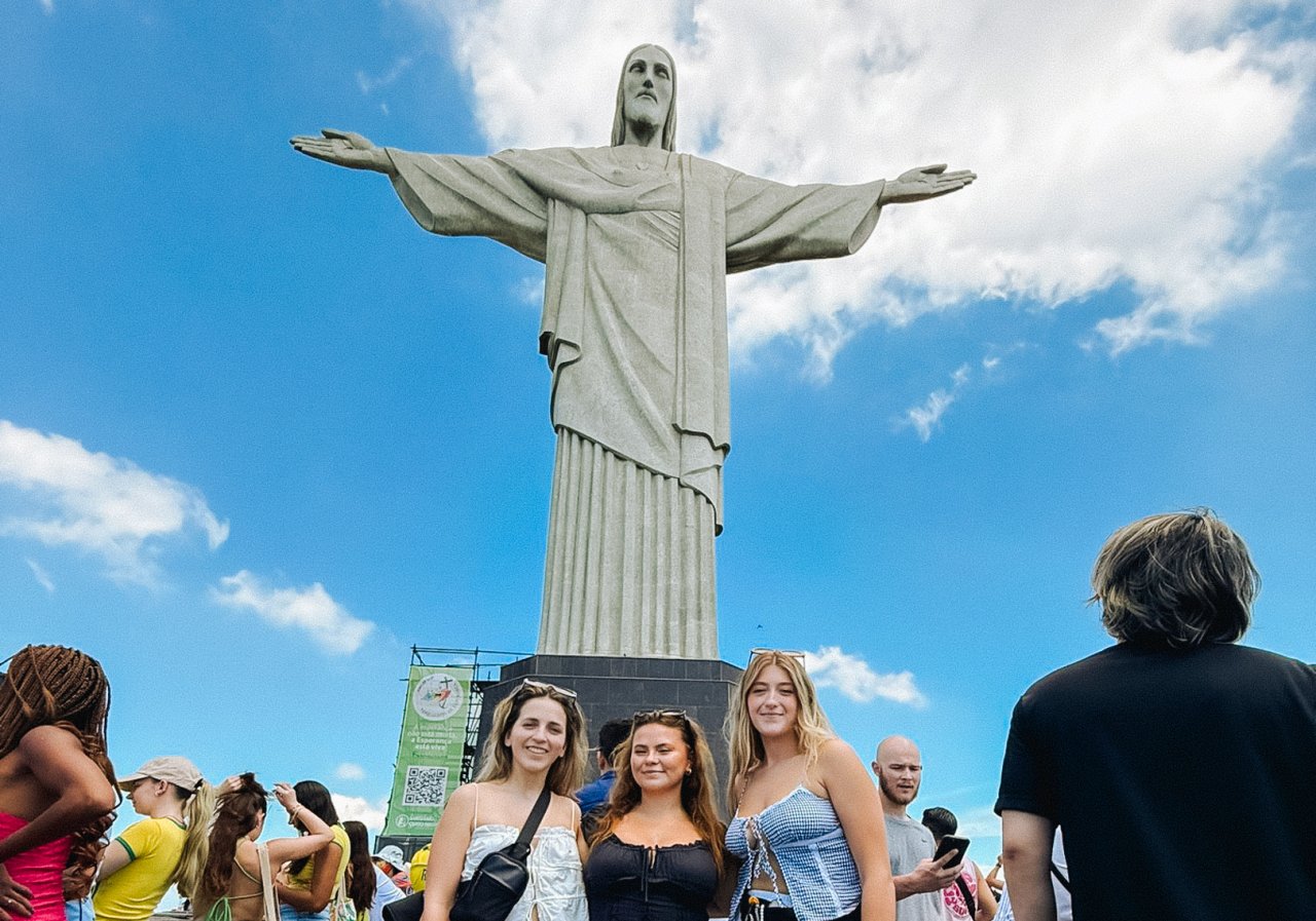 Group of young travellers at the bottom of Christ The Redeemer in Rio de Janeiro
