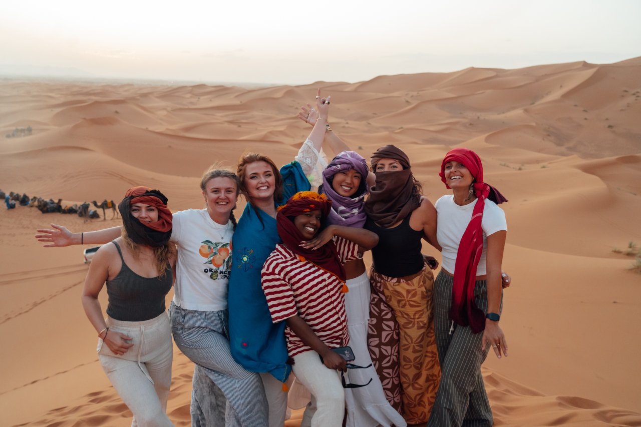 Group of solo travellers in the Sahara Desert whilst on tour in Morocco with TruTravels 